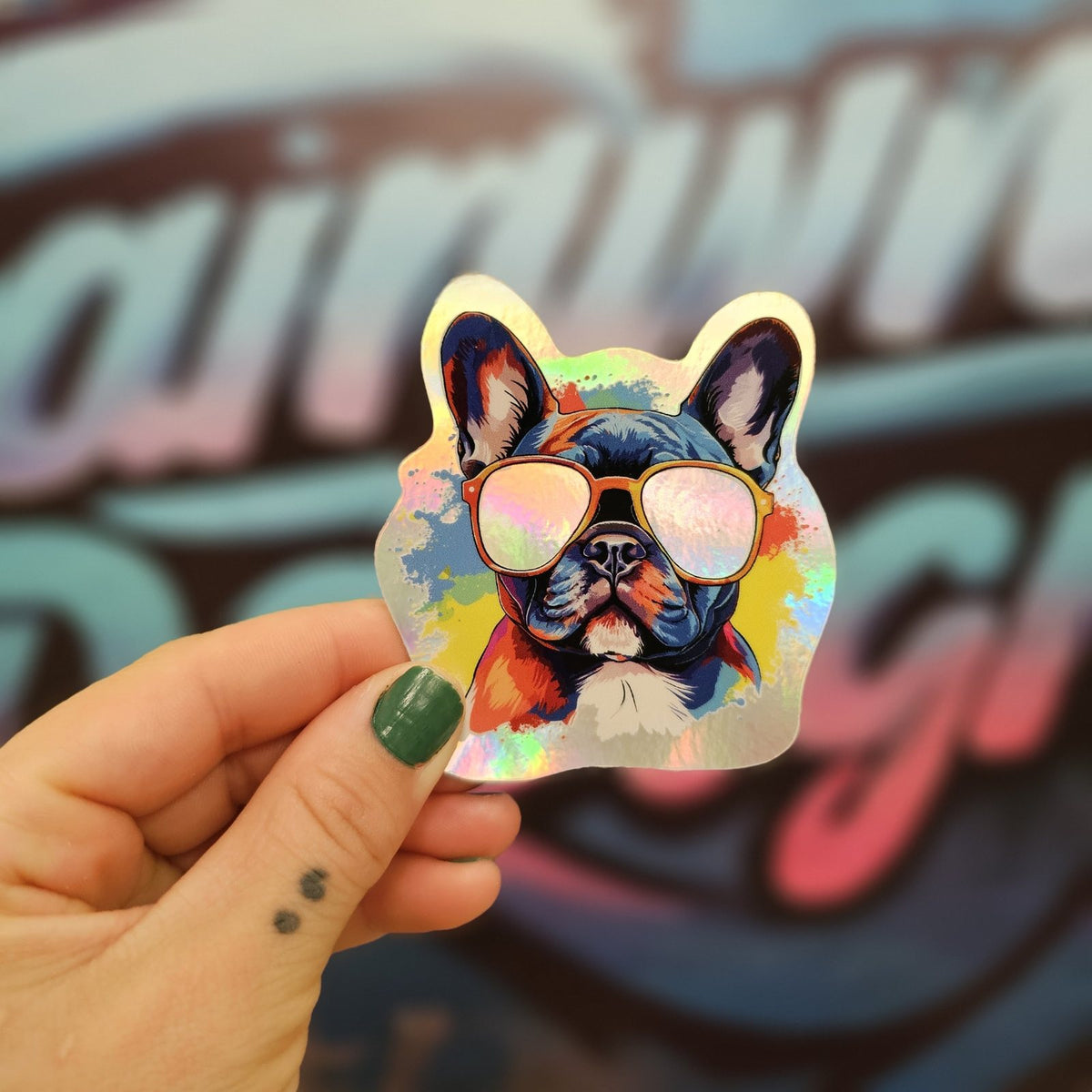 Hand holding a holographic French bulldog sticker