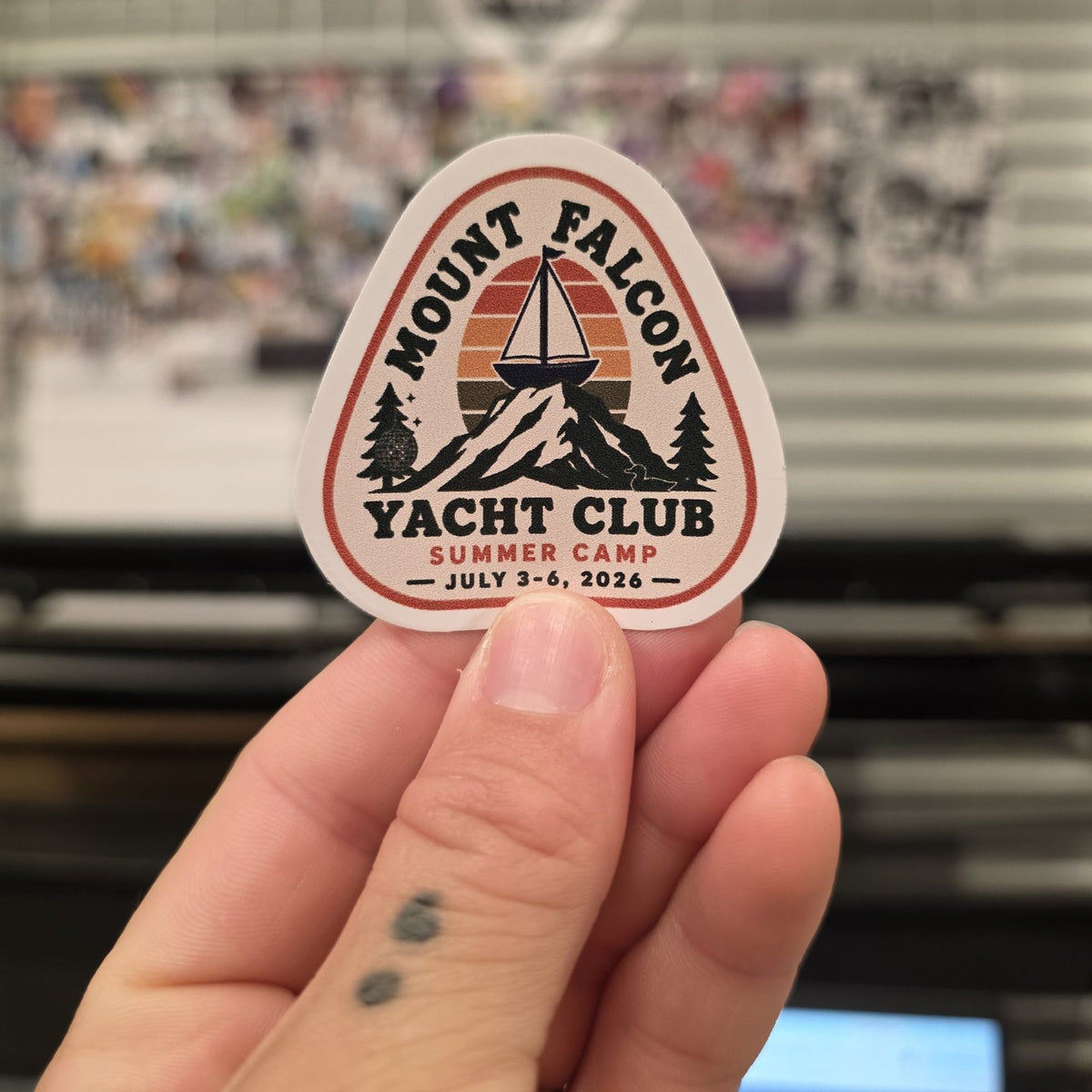 Hand holding a Mount Falcon Yacht Club custom shape sticker