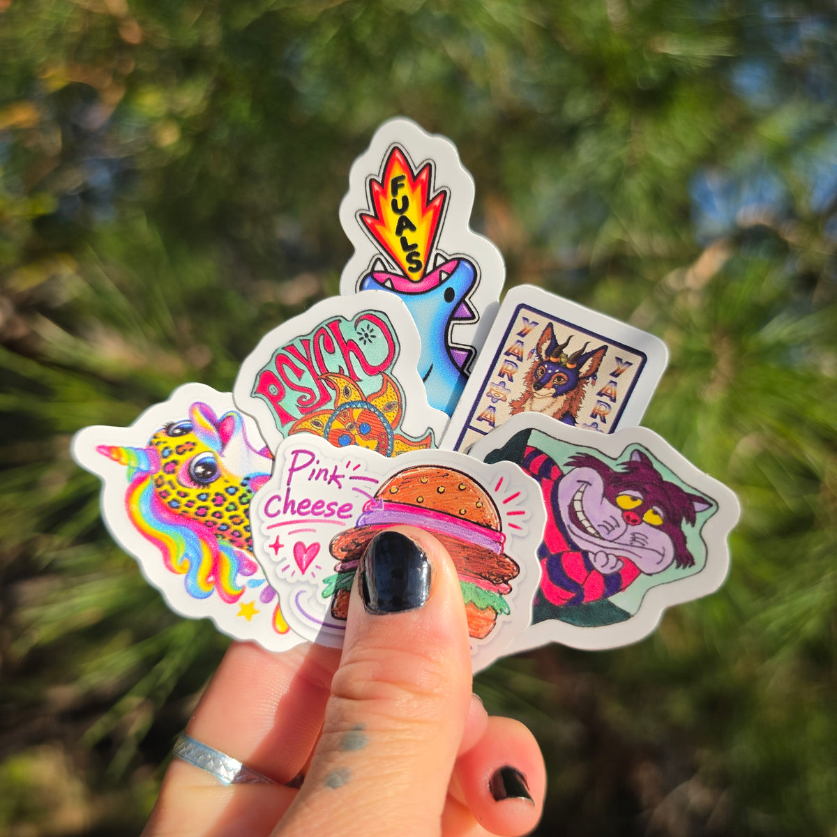 Hand holding a fan of bright, full-color custom die cut stickers