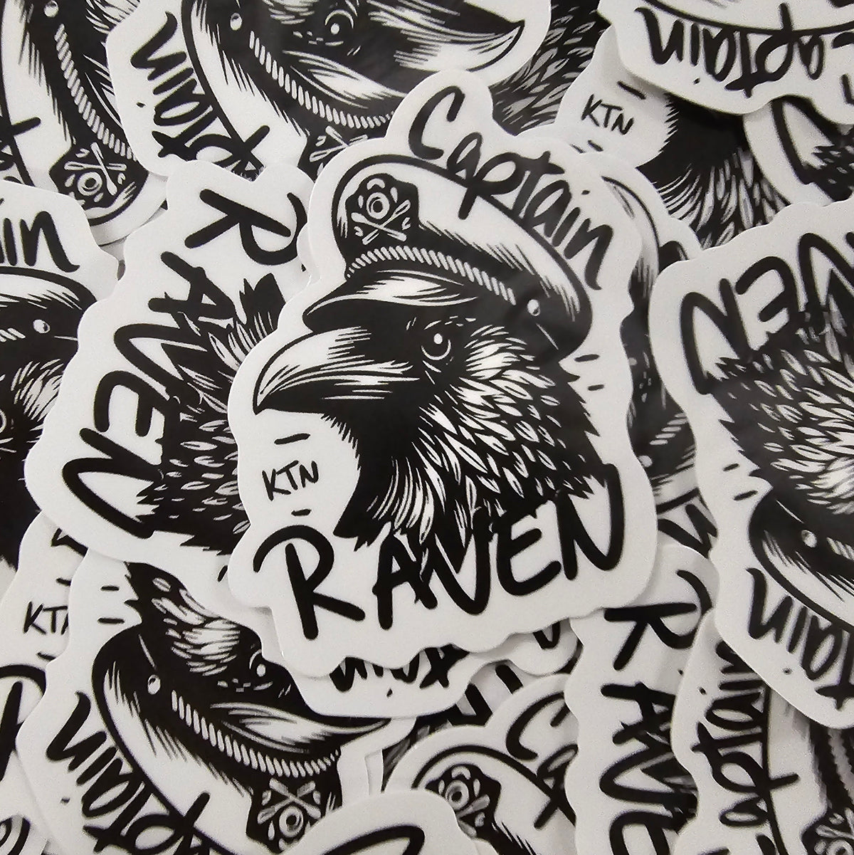 Stack of black and white Captain Raven die cut stickers