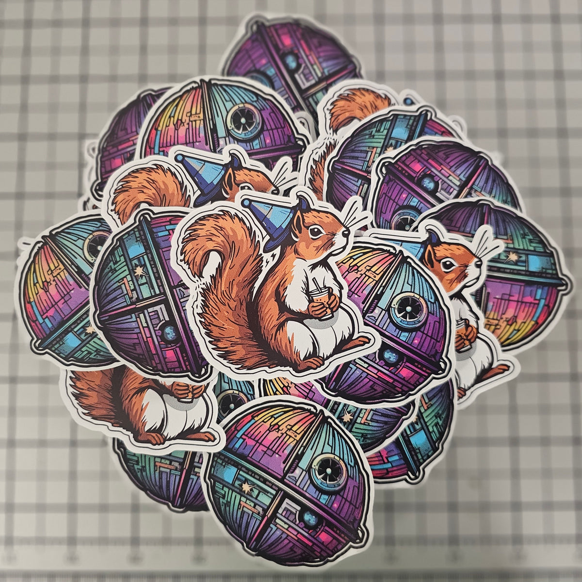 Pile of die cut stickers of a squirrel in a wizard hat and a colorful round space station